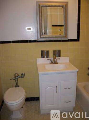 A bathroom with a toilet, sink, and mirror.