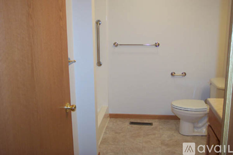 A bathroom with a toilet, a towel bar, and a door.