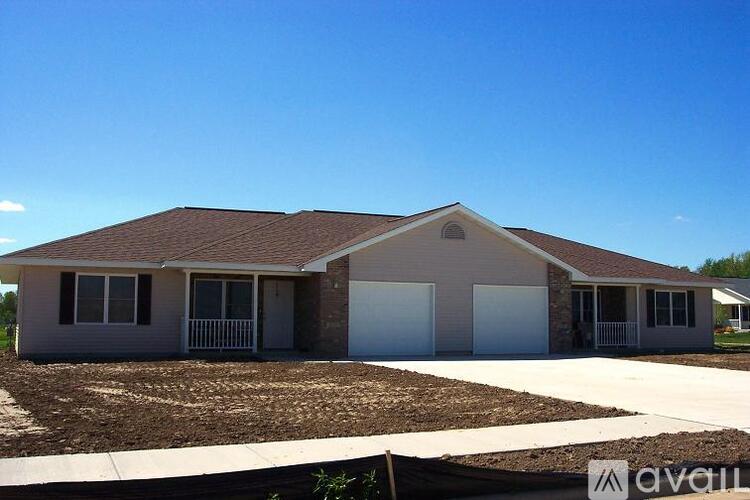A house with a brown roof and a white garage door is for sale.