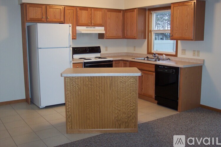 A kitchen with wooden cabinets and a white refrigerator.