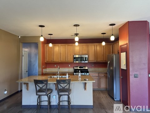 A kitchen with a table and chairs in front of it.