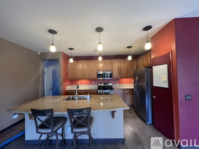 A kitchen with a granite countertop and wooden cabinets.