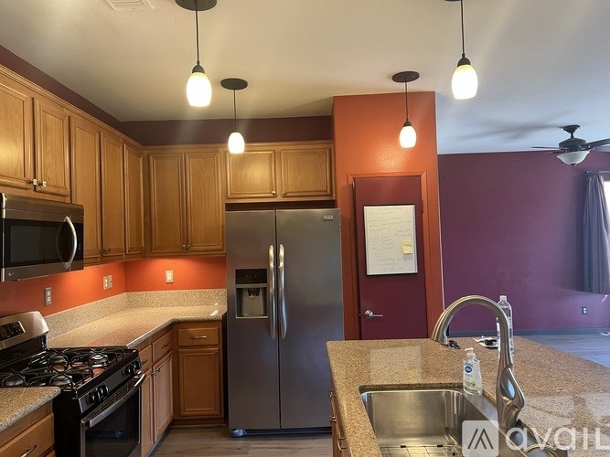 A kitchen with wooden cabinets and a stainless steel refrigerator.