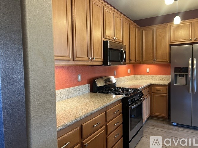 A kitchen with wooden cabinets and a black microwave above the stove.
