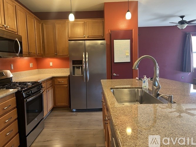 A kitchen with wooden cabinets and a marble countertop.