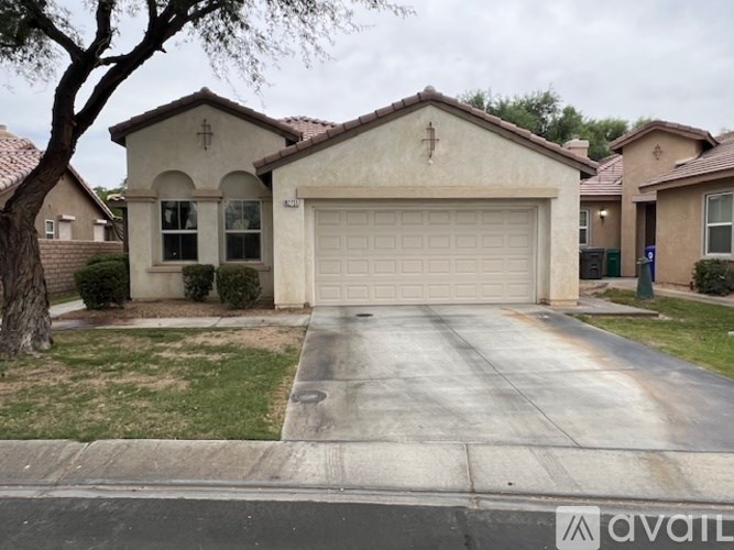 A house with a garage and a driveway in front of it.