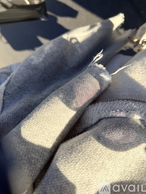 A close-up of a grey fabric with a shadow cast on it.