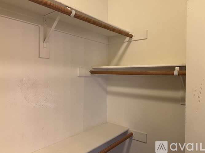 A white wall with a shelf and a whiteboard.