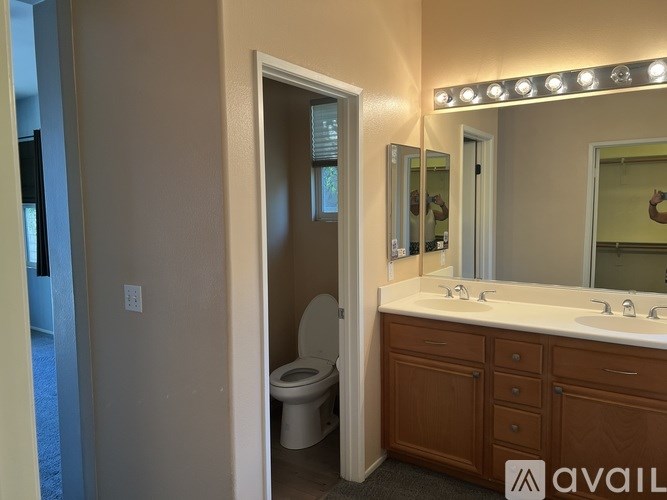 A bathroom with a toilet, sink, and mirror.
