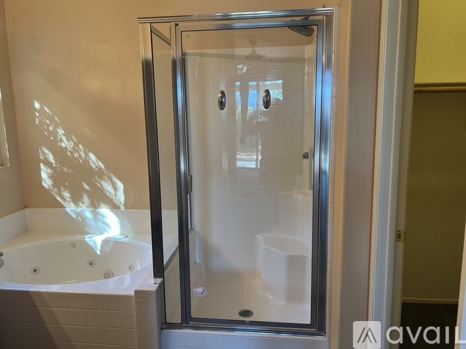 A shower stall with a glass door is in a bathroom.