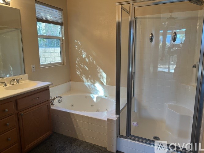 A bathroom with a white tub, sink, and shower.