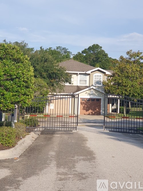 A house with a driveway and gate in front of it.