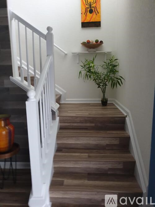 A staircase with a white railing and wooden steps.