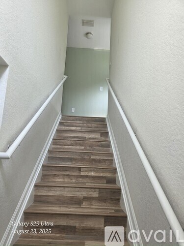 A staircase with wooden steps and white railings.