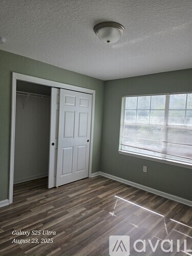 A room with a door and a window with blinds.