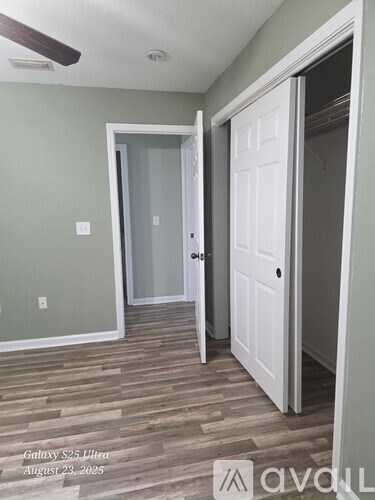 A room with a white door and a white closet with a white ceiling fan.