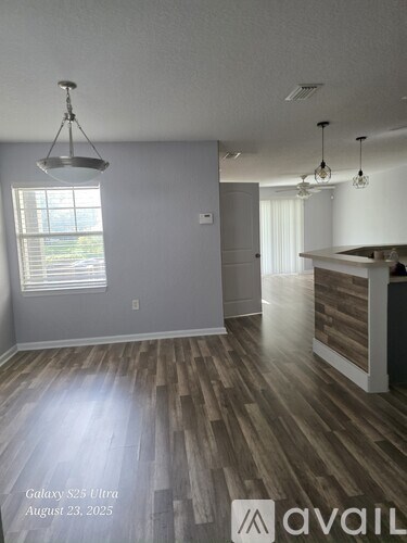 A room with wooden flooring and a bar area.