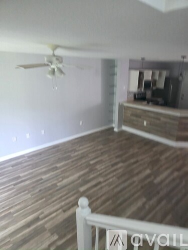 A room with wooden floors and a ceiling fan.