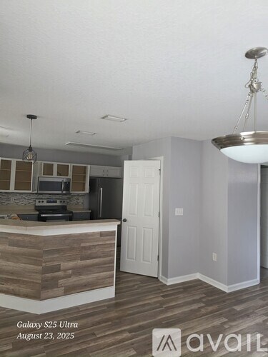 A kitchen with a wooden counter and a white door.