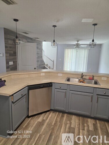 A kitchen with a wooden floor and a large island with a sink.