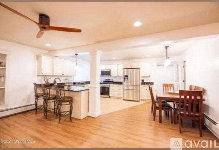 A well-lit kitchen and dining area with wooden floors and furniture.