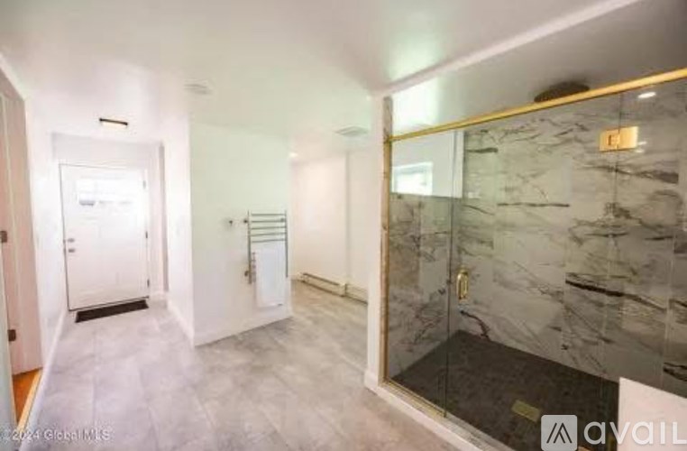 A bathroom with a marble floor and a walk-in shower.