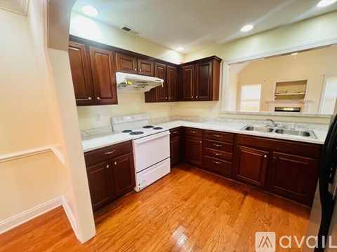 A kitchen with wooden cabinets and a white stove top oven.