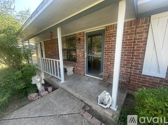 A house with a red brick wall and a white porch.