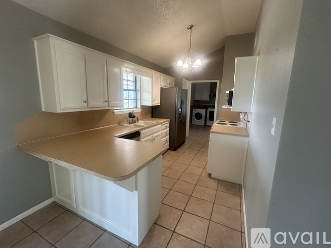 A kitchen with white cabinets and a countertop.