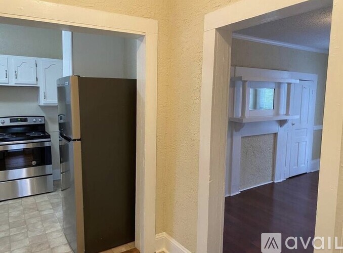 A kitchen with a refrigerator, oven, and stove.