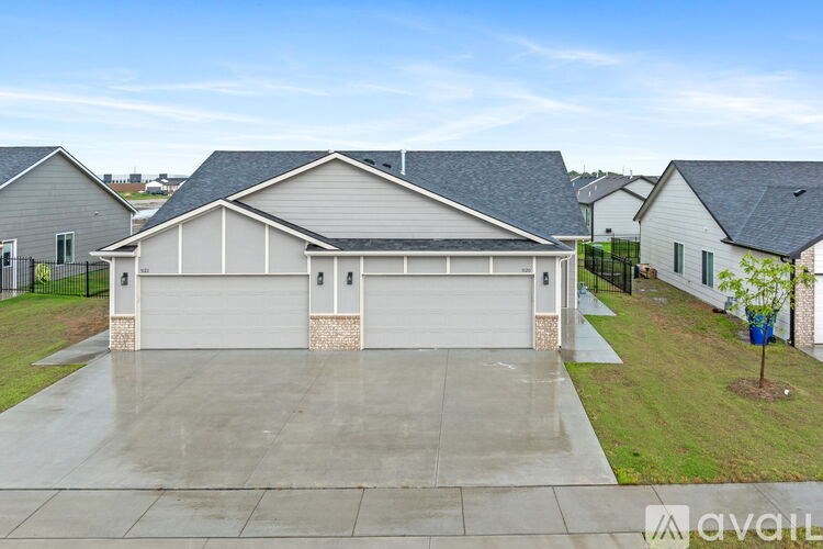 A house with a grey roof and a white garage door is available for sale.