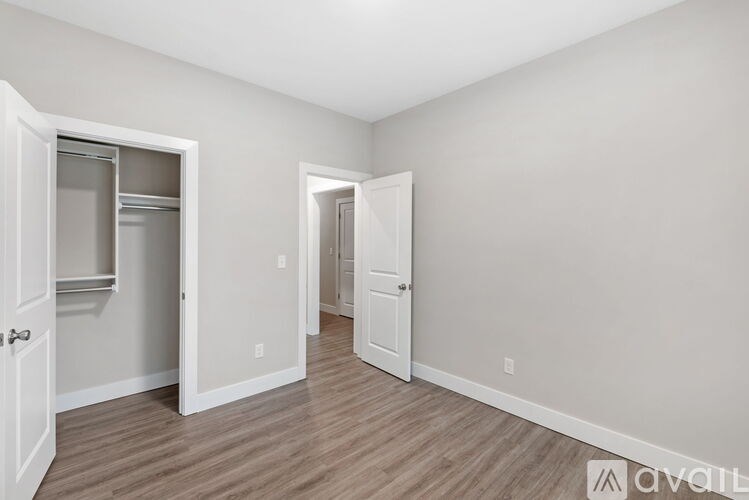 A room with two white doors and a wooden floor.