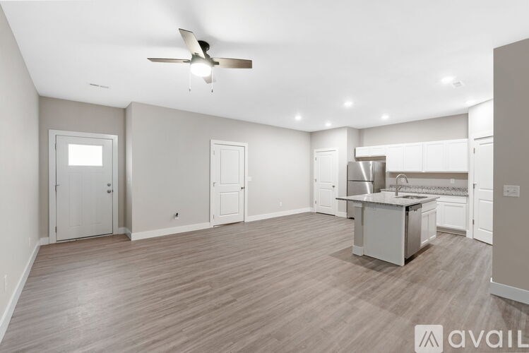 A spacious kitchen with a ceiling fan and lighting fixtures.