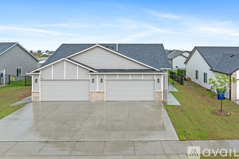 A house with a grey roof and a white garage door is available for sale.