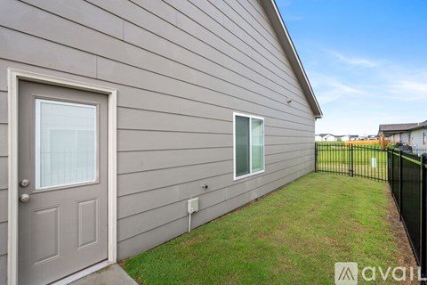 A house with a grey door and a window is for sale.