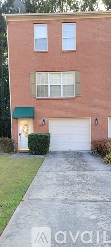 A red brick building with green awnings and white garage doors.