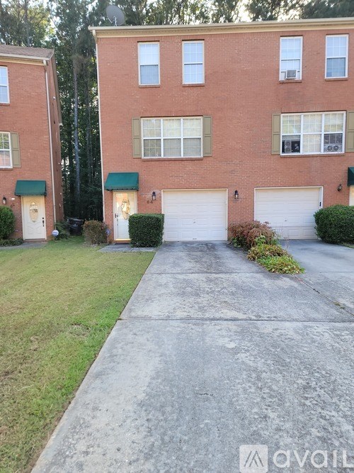 A red brick building with green awnings and white garage doors.