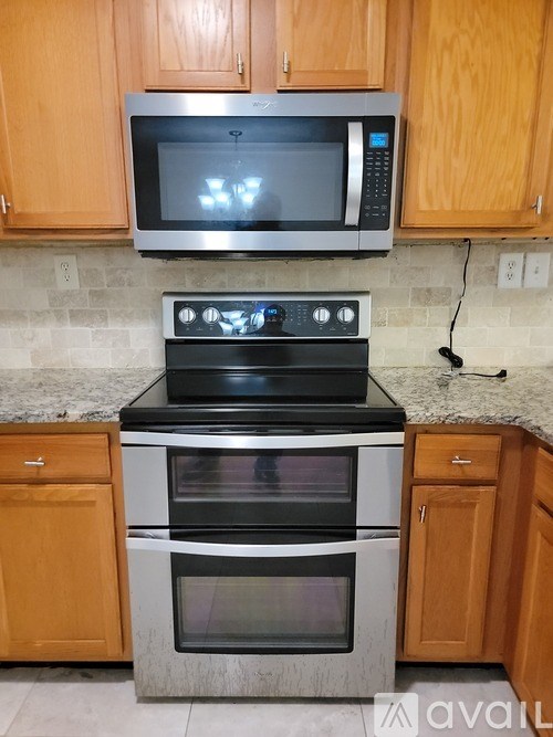 A kitchen with a microwave, oven, and cabinets.