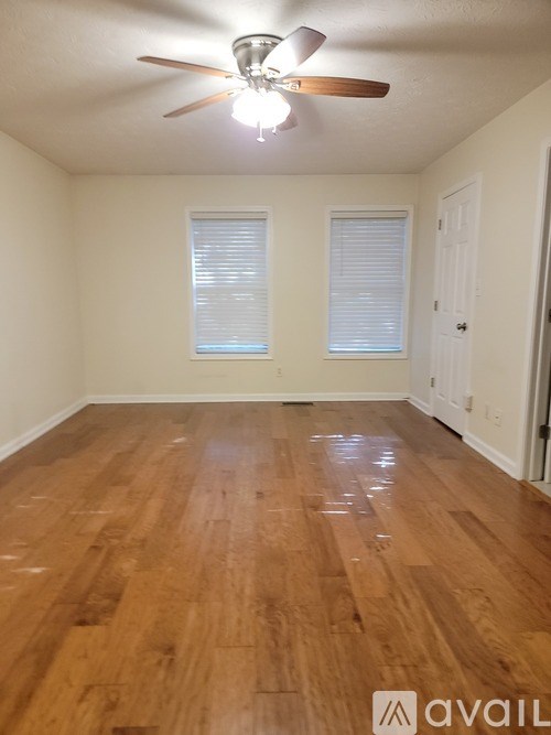 A room with wooden floors and a ceiling fan.