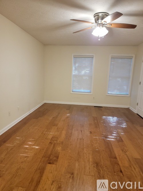 A room with wooden flooring and a ceiling fan.