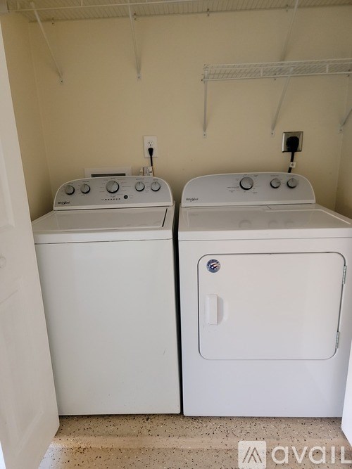 Two white front loading washing machines in a laundry room.