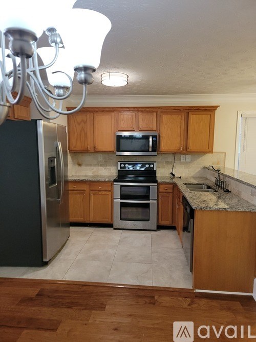 A kitchen with wooden cabinets and a granite countertop.