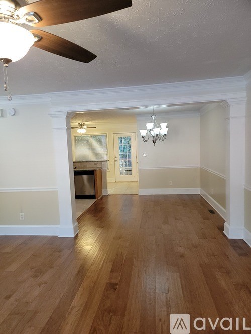 A room with wooden floors and a ceiling fan.