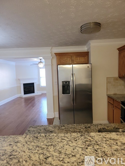 A kitchen with a refrigerator and a fireplace.