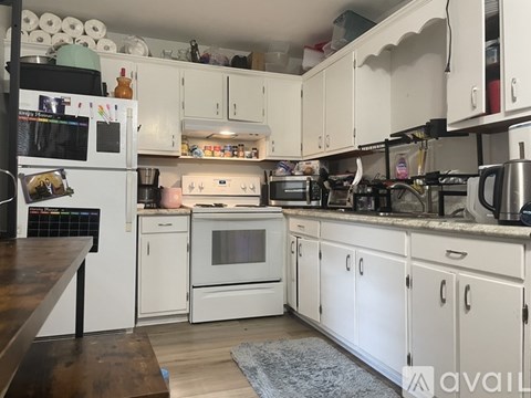 A kitchen with white cabinets and appliances.