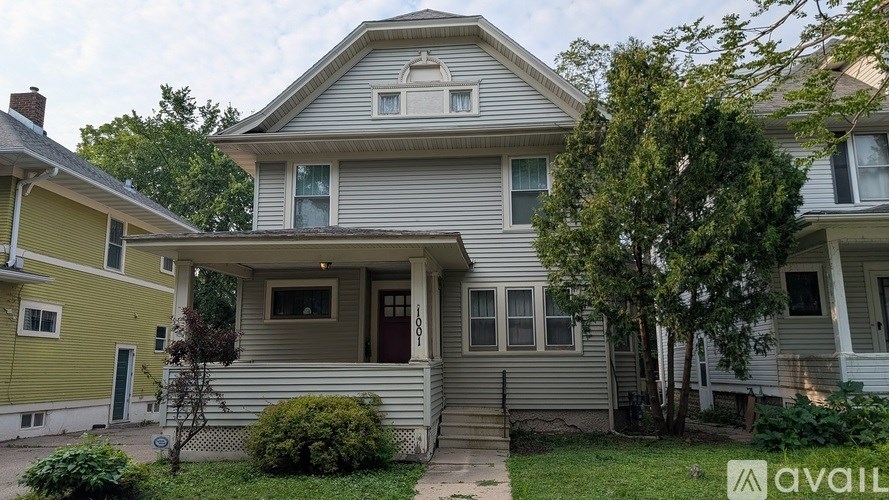 A house with a front yard and a tree.