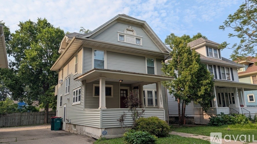 A two-story house with a front porch is for sale.