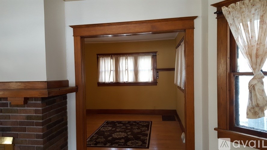 A room with a fireplace and a window with curtains.