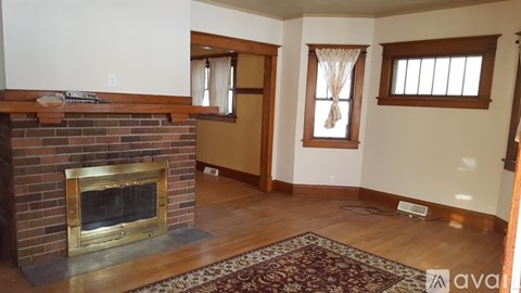 A living room with a fireplace and a rug in front of it.