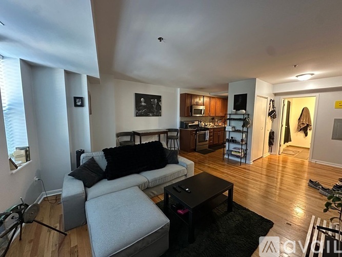 A living room with a grey couch and a black coffee table.